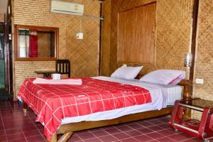a bedroom with a bed with a red blanket at Chian house in Chiang Rai