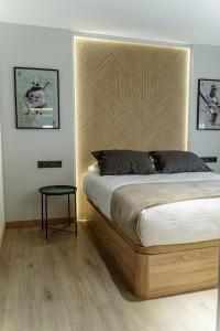レオンにあるHomeandCoのベッドルーム1室(木製ヘッドボードとテーブル付きのベッド1台付)