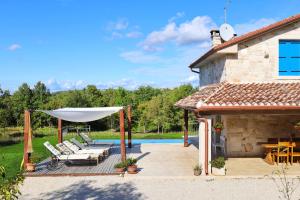 a patio with a white umbrella and a pool at Villa Krug with 3 br and a pool immersed in nature near Buje in Kremenje