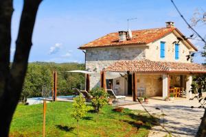 a stone house with a pool in a yard at Villa Krug with 3 br and a pool immersed in nature near Buje in Kremenje