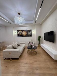 Una sala de estar con un sofá y un televisor. en BOULEVARD REST apartments, en Tashkent