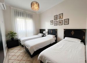 a bedroom with three beds and a potted plant at Atlas Golf resort in Marrakech +82 photos