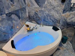 a bathroom with a blue bath tub next to a toilet at Lodevì in Foggia