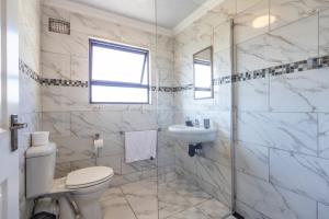 Un baño blanco con inodoro y lavabo. en Haven House, en East London 11 fotos más