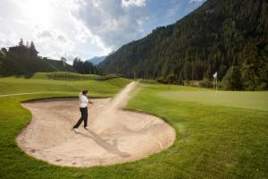 un hombre parado en la arena en un campo de golf en Alpengasthof Pichler, en Sankt Veit in Defereggen