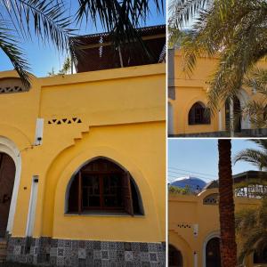 a yellow building with a palm tree next to it at The Residence in Luxor