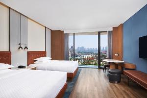 a hotel room with two beds and a large window at Four Points by Sheraton Nanchang, Xihu in Nanchang +56 photos