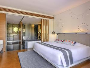 a bedroom with a large white bed and a bathroom at Veranda High Resort Chiang Mai - MGallery Collection, Accor Hotel in Hang Dong
