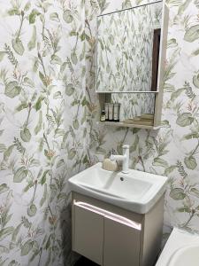 MamaにあるCozy Oasis by Redaの花柄の壁紙を用いたバスルーム(シンク付)