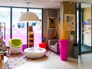 Una tienda con jarrones rosas y morados y una mesa. en ibis Styles Montbéliard, en Montbéliard