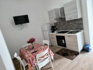 a kitchen with a table with a vase of flowers on it at B&B REVOLUTION 2 BED e BREAKFAST in Caserta