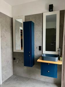 a bathroom with a blue sink and a mirror at Dom na wynajem Śrem 52 in Nochowo