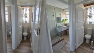 a bathroom with two toilets and a glass shower at The Pearl in the Winelands in Paarl +13 photos