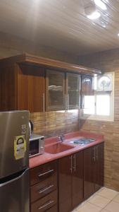 a kitchen with a sink and a microwave at شقق ريحانة أبها للشقق المخدومة in Abha