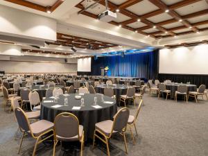 une salle de conférence avec des tables et des chaises ainsi qu'un podium dans l'établissement Fairmont Resort Blue Mountains MGallery Collection, à Leura 243 autres photos