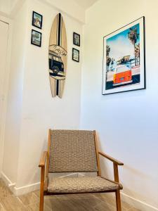 Una silla en una habitación con una tabla de surf en la pared. en Charmant 2 pièces piscine plage & 15 min de Cannes, en Mandelieu-la-Napoule 18 fotos más