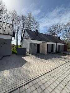 a large white building with a garage at Dom na wynajem Śrem 52 in Nochowo +4 photos