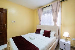 een slaapkamer met een wit bed met een raam bij Shwari Home Stays in Kisii