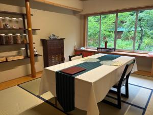 cocina con mesa con sillas y ventana en 信夫温泉青州, en Fukushima