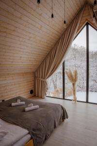 Un dormitorio con una cama y una ventana grande. en Domki Momenty, en Słajszewo