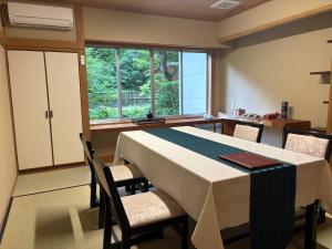 Un comedor con mesa y sillas y una ventana. en 信夫温泉青州, en Fukushima