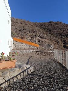 a building with a plant on the side of a hill at Anmar, rincón de desconexión y naturaleza in Playa de Tasarte