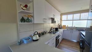 a kitchen with white cabinets and a stove top oven at The Pearl in the Winelands in Paarl