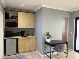 a kitchen with wooden cabinets and a table at 14 Wylant Street in Welgemoed