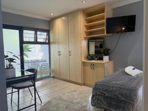 a bedroom with a bed and a desk and a television at 14 Wylant Street in Welgemoed