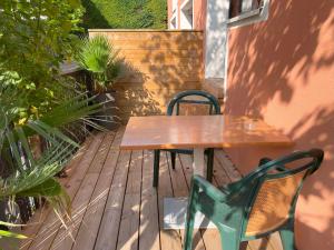 a wooden table and chairs on a wooden deck at Studio Duplex le Jungle - Bourgoin Centre in Bourgoin