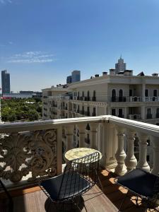 Un balcón con dos sillas y una mesa y un edificio. en BOULEVARD REST apartments, en Tashkent 22 fotos más