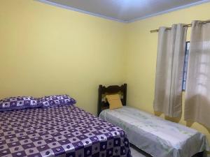 a bedroom with two beds and a window at PENSÃO da DONA FATIMA in Conceição do Mato Dentro