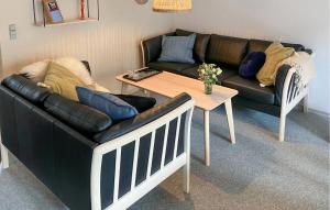 a living room with a couch and a table at Pet Friendly Home In Vestervig With Sauna in Tåbel +15 photos