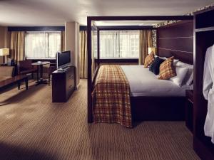 a hotel room with a large bed and a desk at Mercure Glasgow City Hotel in Glasgow +67 photos