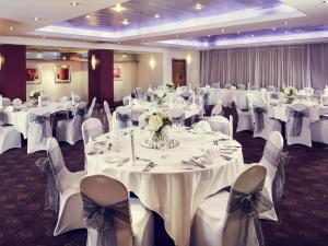 a banquet room with white tables and chairs at Mercure Glasgow City Hotel in Glasgow