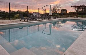 una piscina con sedie e un tramonto sullo sfondo di Cozy Home In Zminj a Jurići Altre 16 foto