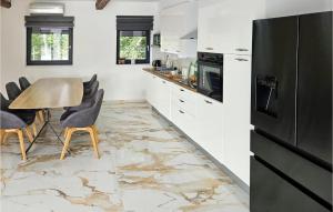 una cucina con pavimento in marmo, tavolo e sedie di Cozy Home In Zminj a Jurići