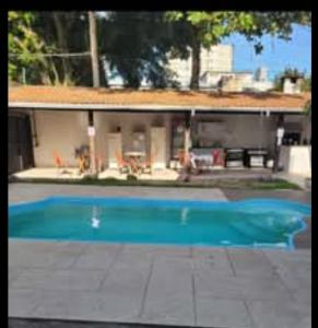 a large blue swimming pool in front of a house at Hostel da Dani in Balneário Camboriú
