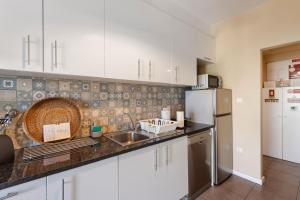 a kitchen with white cabinets and a sink and a refrigerator at Destiny Oporto in Maia