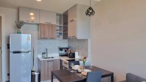 Una cocina con una mesa y un refrigerador blanco. en Silk Ao Nang Condominium, en Ao Nang Beach