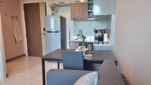 una cocina con mesa y una cocina con refrigerador en Silk Ao Nang Condominium, en Ao Nang Beach