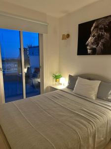 a bedroom with a large bed and a large window at Ocean View Skyline Apartment ‚Hakuna Matata‘ in Albufeira