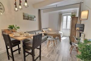 Una sala de estar con una mesa y sillas y un sofá. en Studio 4 personnes Hyper centre, en Cannes