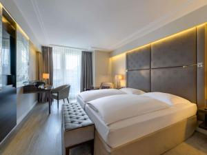 慕尼黑慕尼黑铂尔曼酒店的一间酒店房间，里面有两张床和一张桌子。