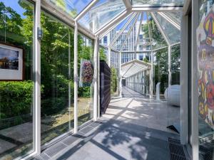 a glass house with a pathway in a garden at Pullman Munich in Munich