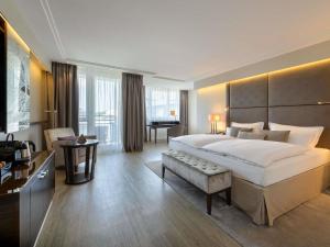 a hotel room with a large bed and a desk at Pullman Munich in Munich +117 photos