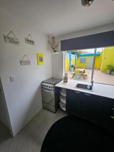 uma cozinha com um fogão, um lavatório e um pátio em Raven's Casa del Mar em Willemstad