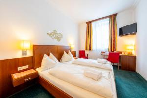 ein Hotelzimmer mit Bett und Schreibtisch in der Unterkunft Hotel Krug in Gumpoldskirchen