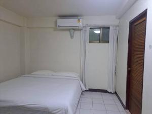 a bedroom with a white bed and a window at BaanSathorn21 in Bangkok