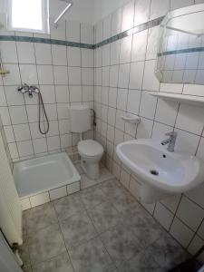a white bathroom with a sink and a toilet at Bükfalva Bercsényi13 in Bük